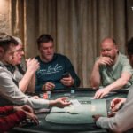Ein Stapel von Pokerchips in verschiedenen Farben und Werten, der auf einem grünen Pokertisch liegt.