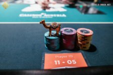 Ein Mann und eine Frau spielen Poker am Tisch, während sie Karten halten und Chips stapeln.