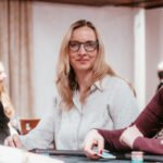Ein Mann spielt Poker an einem Tisch im Casino, umgeben von anderen Spielern und Chips.