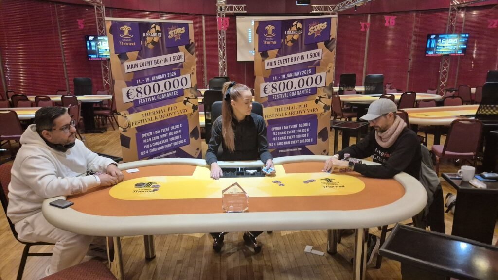 Ein Stapel von Pokerchips unterschiedlicher Farben und Werte auf einem grünen Pokertisch.