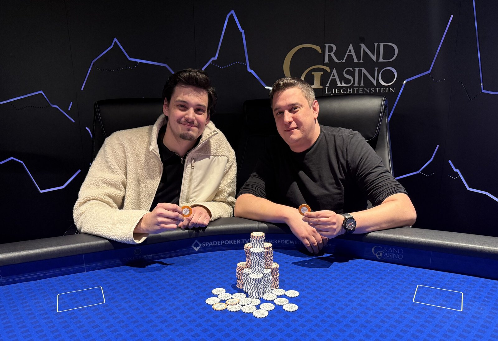 Ein Mann mit einer Pokerkarte in der Hand, der konzentriert auf seinen Gegner schaut. Er sitzt an einem Pokertisch, umgeben von Chips und anderen Spielern.