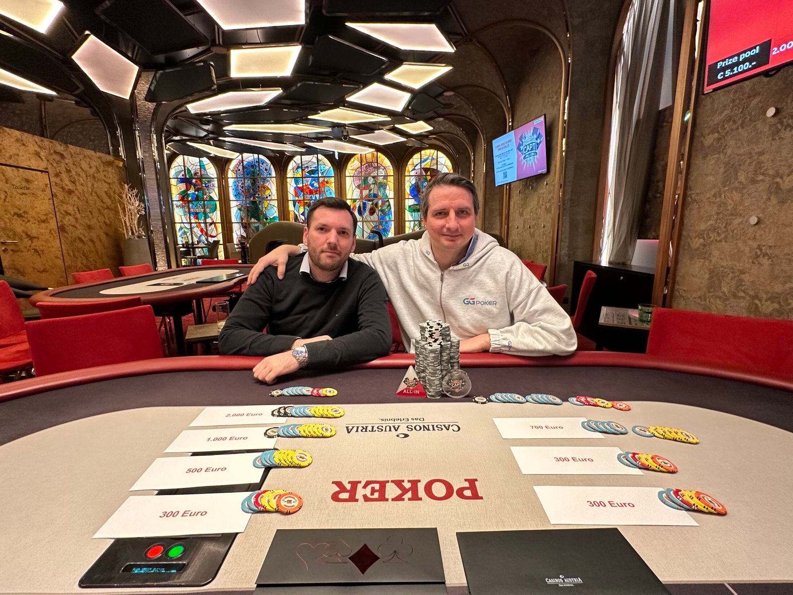 Ein Mann und eine Frau sitzen an einem Pokertisch und spielen Texas Hold'em. Der Mann hat eine Hand mit Pik-König und Karo-Dame, während die Frau eine Hand mit Herz-König und Kreuz-König