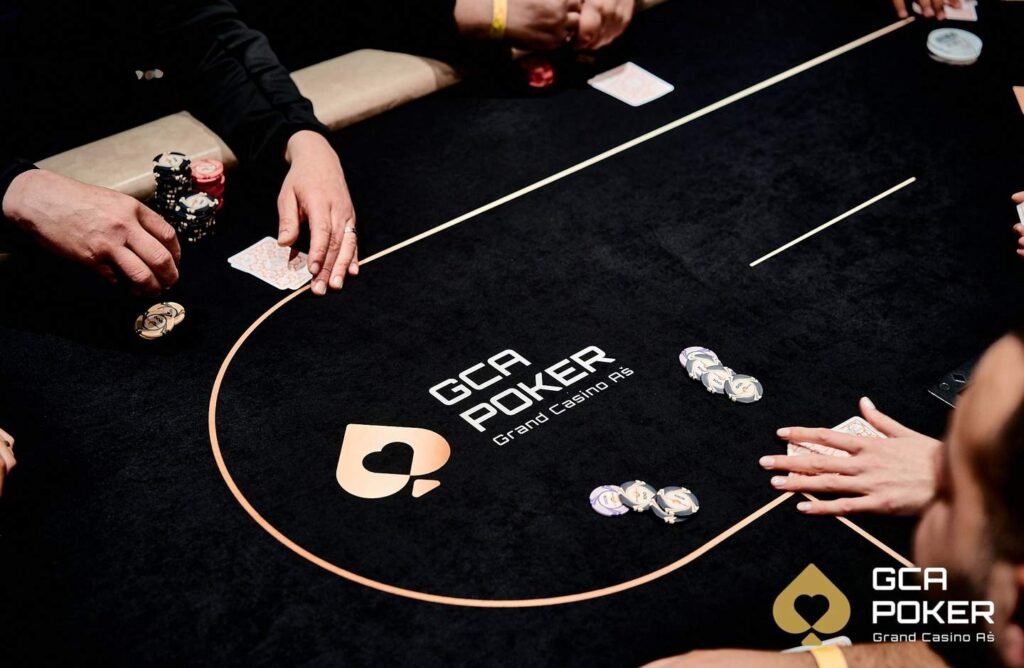 Ein kunstvoll gestalteter Pokertisch mit grünem Filz, umgeben von leeren Stühlen und einer Mischmaschine für Spielkarten.