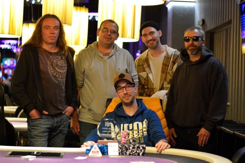 Ein Mann und eine Frau sitzen an einem Pokertisch, der Mann hält seine Karten verdeckt, während die Frau ihre Karten betrachtet. Ein Stapel Chips liegt in der Mitte des Tisches. Die Atmosph