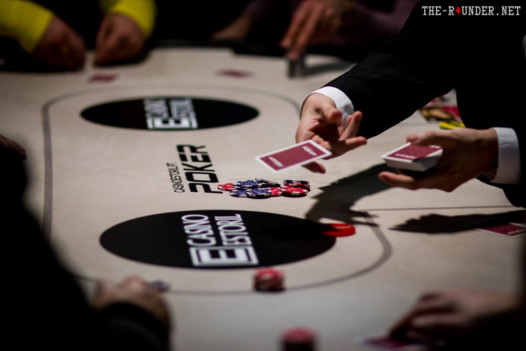 Ein professioneller Pokerdealer mischt Karten an einem Spieltisch im Casino Estoril.
