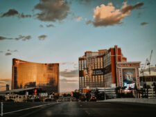 Ein luxuriöser Pokertisch mit grünem Filz und goldenen Details, umgeben von eleganten Stühlen und einer glamourösen Beleuchtung in einem exquisiten Raum im Wynn Casino.
