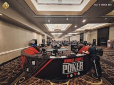 Ein Foto von einem Pokertisch im Horseshoe Casino in Las Vegas während der World Series of Poker. Spieler sitzen um den Tisch herum, Karten und Chips liegen verteilt. Im Hintergrund sind weitere Spieler und