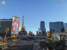 Ein belebter Abschnitt des Las Vegas Strip bei Nacht, mit den beleuchteten Fassaden des Horseshoe, Aria, Cosmopolitan und Paris Hotels im Vordergrund. Menschenmassen und Fahrzeuge bewegen