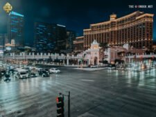 Ein belebter Blick auf den Las Vegas Strip mit den Hotels Bellagio und The Cosmopolitan im Vordergrund, umgeben von lebhaften Lichtern und Menschenmassen.