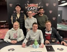 Ein Siegerfoto des CAPT Opener Pokerturniers, auf dem der Gewinner mit einem breiten Lächeln und einer Trophäe in der Hand posiert. Im Hintergrund sind jubelnde Zuschauer und eine