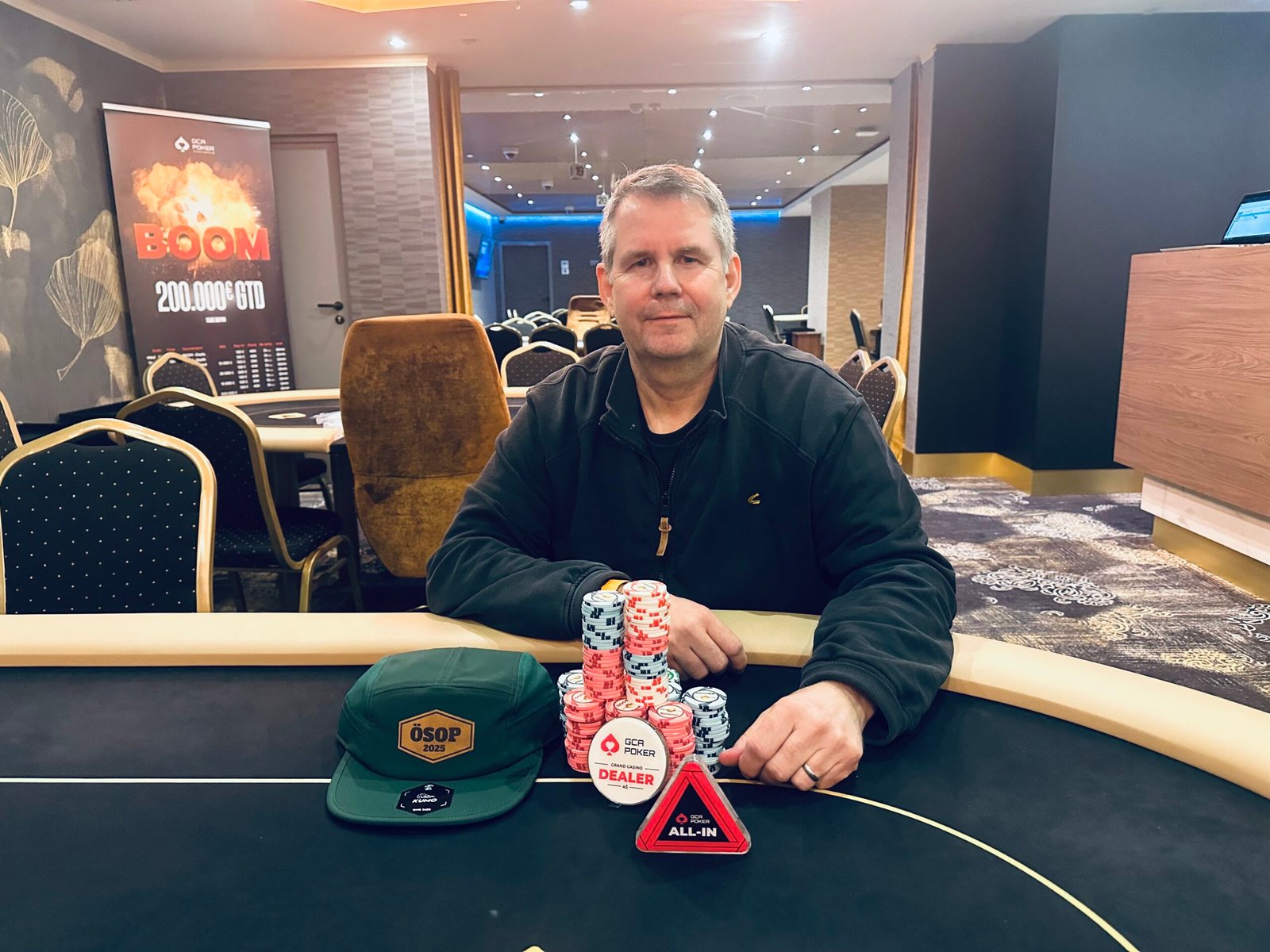 Ein Pokerturnier mit dem Titel "OESOP PLO Turbo Bounty", mit Spielkarten und Pokerchips auf dem Tisch, während Spieler in Aktion sind.