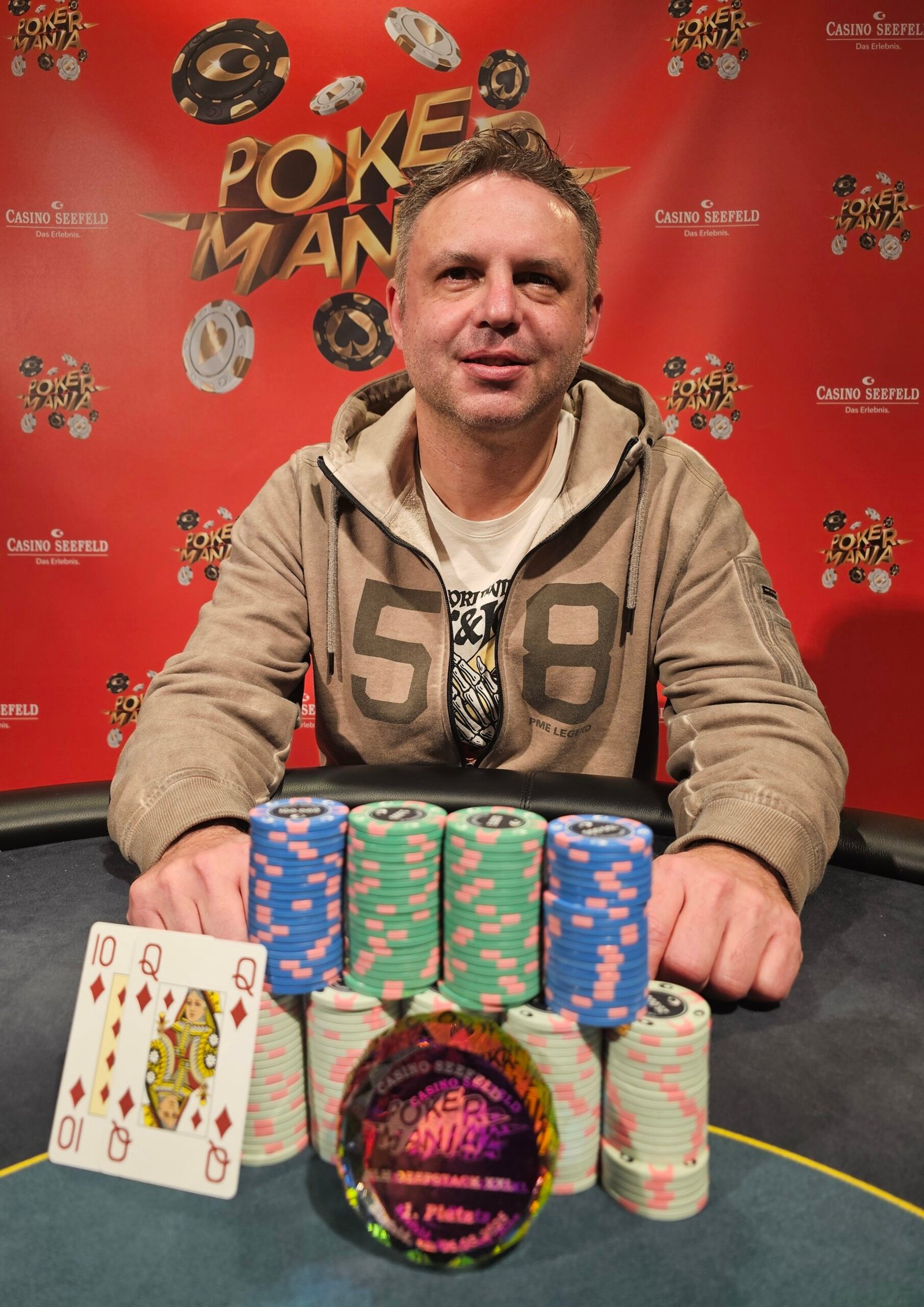 Ein Mann spielt Poker in einem eleganten Casino in Seefeld. Er hat eine schwarze Jacke an und konzentriert sich auf seine Karten. Im Hintergrund sind andere Spieler und eine stilvolle Einrichtung zu
