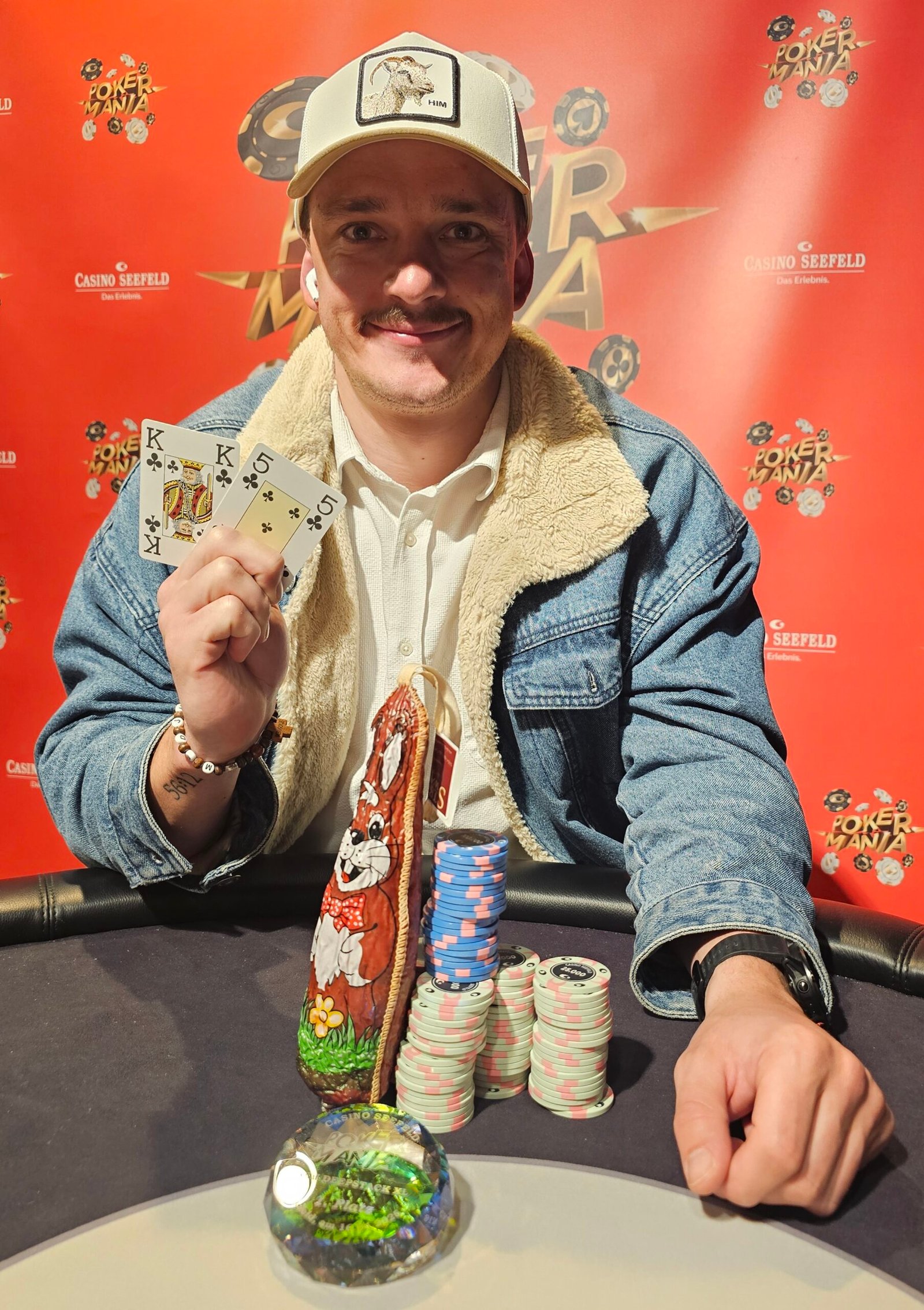 Ein Haufen farbenfroher Pokerchips auf einem grünen Pokertisch.