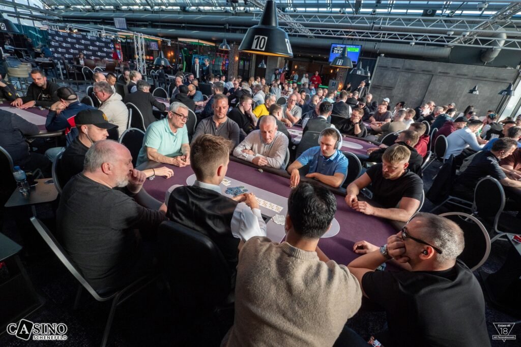 Ein buntes Bild von Spielkarten, die auf einem Tisch ausgelegt sind, um ein Pokerblatt zu bilden. Die Karten sind in verschiedenen Farben und Werten und liegen auf einem grünen Filztisch.