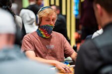 Ein bunter Haufen von Pokerchips in verschiedenen Farben und Werten, die auf einem grünen Pokertisch liegen.