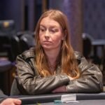 Ein Mann und eine Frau sitzen an einem Pokertisch und spielen Texas Hold'em. Der Mann hat einen Stapel Jetons vor sich und schaut konzentriert auf seine Karten, während die Frau neben ihm mit gespanntem