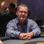 Ein Mann und eine Frau spielen Poker in einem eleganten Casino mit grünen Filz-Tischen und professionellen Spielkarten. Der Mann hat einen Anzug an und die Frau trägt ein elegantes Abendkleid. Die Atmosph