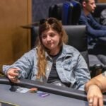 Ein professionell gestalteter Pokertisch mit grünem Filz und einem Satz von Pokerchips in verschiedenen Farben, die auf dem Tisch verteilt sind. In der Mitte des Tisches liegen Spielkarten und