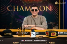 Ein Mann in einem dunklen Anzug und einer Sonnenbrille hält einen riesigen Pokal in die Luft, umgeben von jubelnden Menschen.