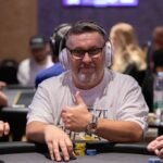 Ein Stappel von Pokerchips in verschiedenen Farben und Werten, die auf einem Pokertisch liegen.