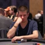 Ein professioneller Pokertisch mit grünem Filz, umgeben von Stühlen und Chips, bereit für ein spannendes Kartenspiel.
