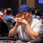 Ein Mann und eine Frau sitzen an einem Pokertisch und spielen eine Partie Poker. Der Mann hat gerade seine Karten angeschaut und überlegt, während die Frau mit einem selbstbewussten Blick auf ihre Karten schaut.