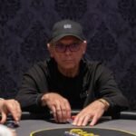 Ein Mann und eine Frau sitzen an einem Pokertisch und spielen gegeneinander. Der Mann hat eine ernste Miene, während die Frau konzentriert auf ihre Karten schaut. Die Szene spielt in einem stil