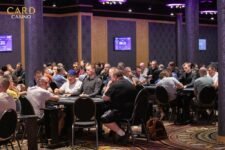 Alt-Text: Ein Mann und eine Frau spielen Poker an einem Tisch. Der Mann hat einen Stapel Chips vor sich liegen, während die Frau ihre Karten betrachtet. Beide haben konzentrierte Gesichtsausdr