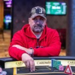 Ein Spieler wirft eine Handvoll Pokerchips in die Mitte des Spieltisches während einer Pokerrunde in einem Casino.