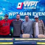 Ein professionell gestalteter Pokertisch mit grünem Filz und einem Stapel von Pokerchips in verschiedenen Farben. In der Mitte des Tisches liegen Spielkarten und die Spieler sind in intensives Spiel vertie